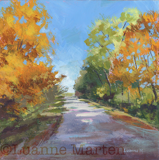 Painting of a road flanked by trees in bright fall foliage of oarnges, gold, green, signed 'Luanne Marten'.